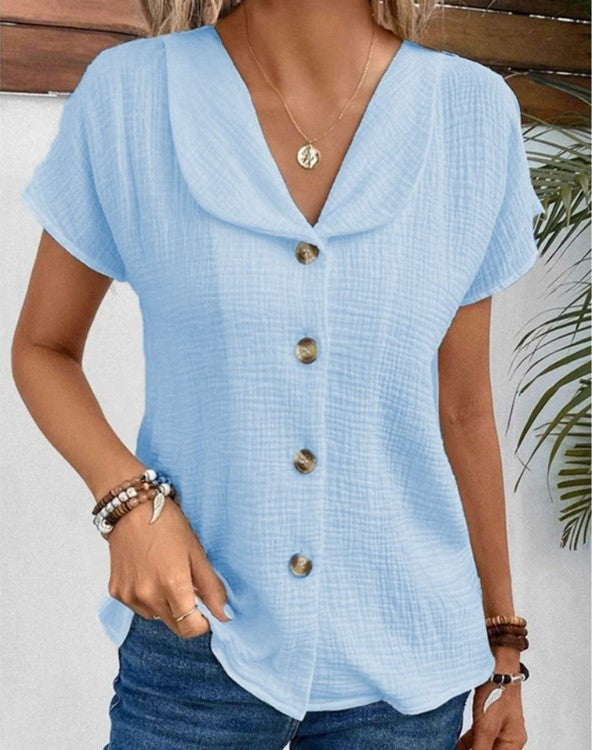 Imagen de blusa elegante de mujer con botones decorativos y cuello. Ideal para combinar con tu guardarropa casual.