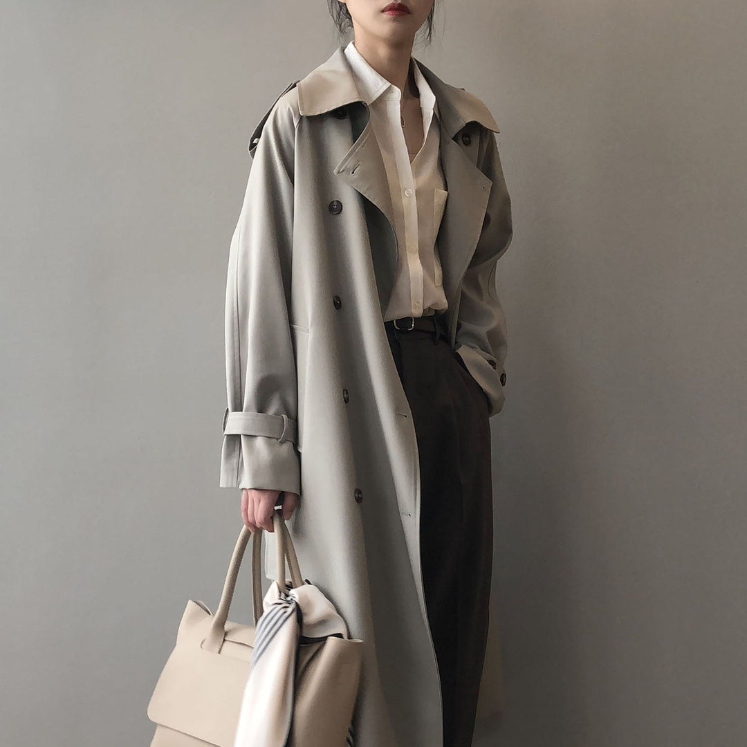 Gabardina elegante de mujer con doble botonadura, cinturón y solapas. Chaqueta de abrigo sofisticada.