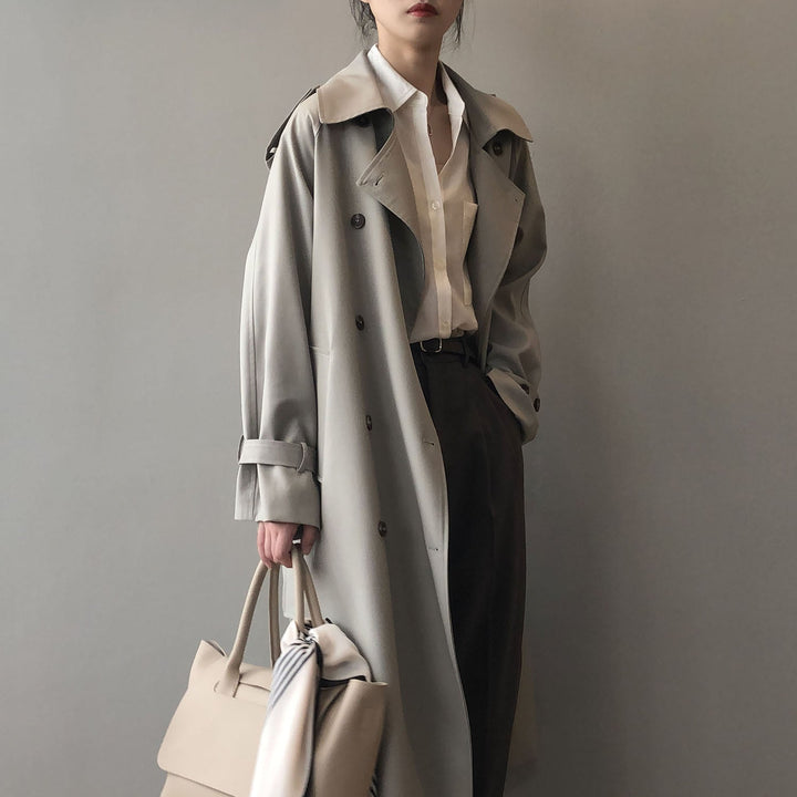 Gabardina elegante de mujer con doble botonadura, cinturón y solapas. Chaqueta de abrigo sofisticada.