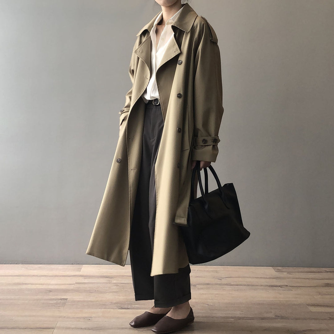 Mujer vistiendo gabardina clásica de doble botonadura. Abrigo elegante para un outfit sofisticado de otoño.
