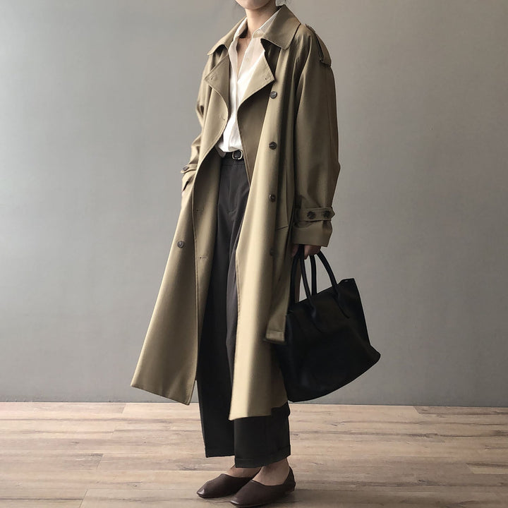 Mujer vistiendo gabardina clásica de doble botonadura. Abrigo elegante para un outfit sofisticado de otoño.