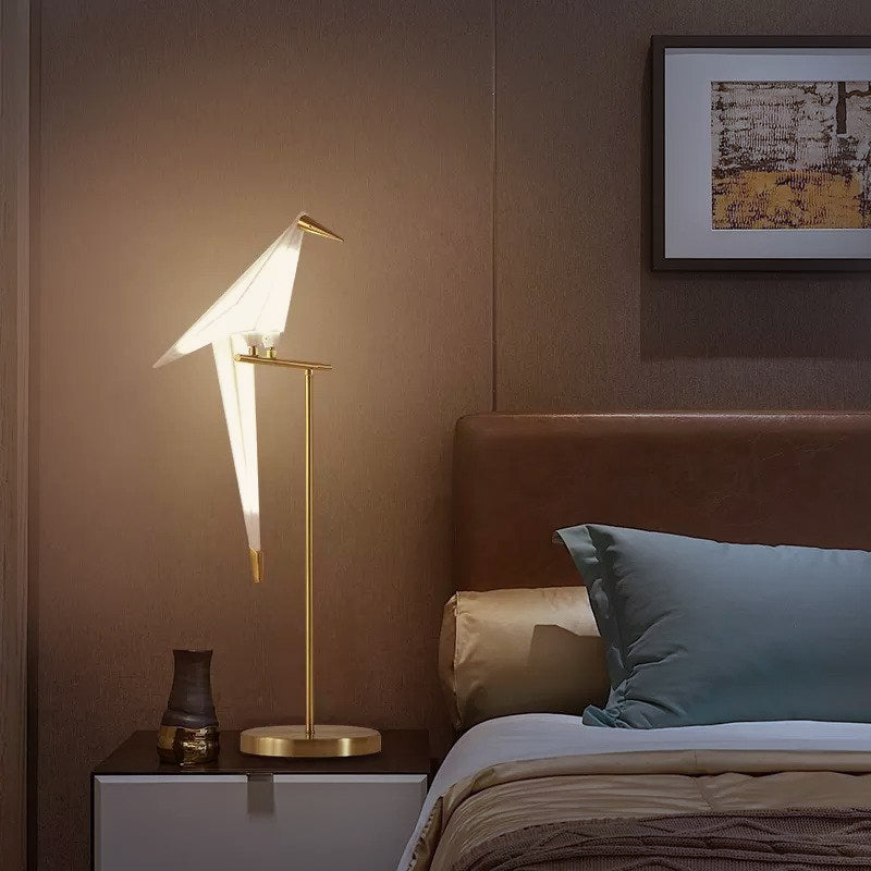 Lámpara LED con pájaro origami que emite luz cálida ambiental. Ideal para crear atmósfera acogedora en el hogar.
