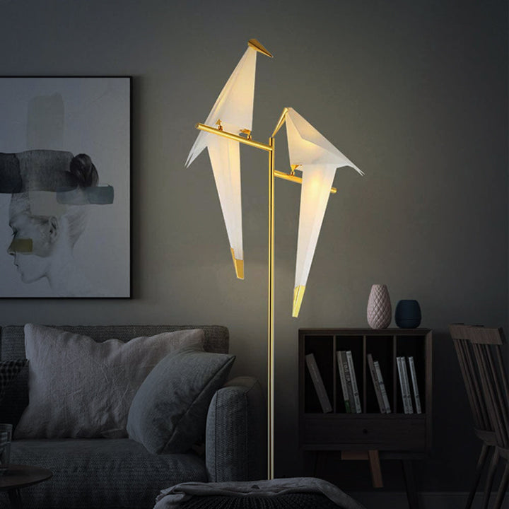 Versátil lámpara de pie y mesa con diseño de pájaro origami. Iluminación LED cálida y estructura flexible.