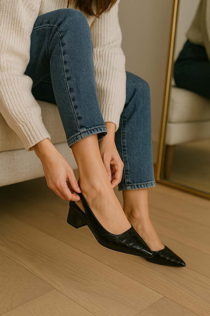 Pumps negros de mujer, elegantes con punta afilada y acabado brillante. Estilo clásico.