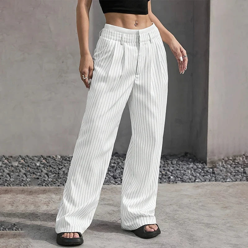 Detalle de cintura alta en pantalones de mujer de pierna ancha. Tejido plisado, look moderno y elegante.