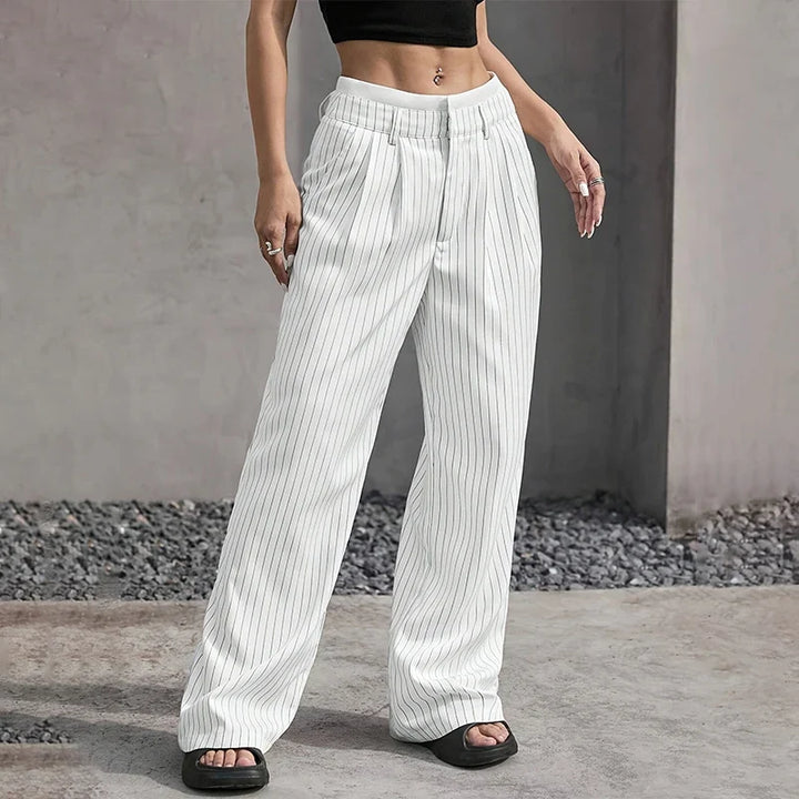 Detalle de cintura alta en pantalones de mujer de pierna ancha. Tejido plisado, look moderno y elegante.