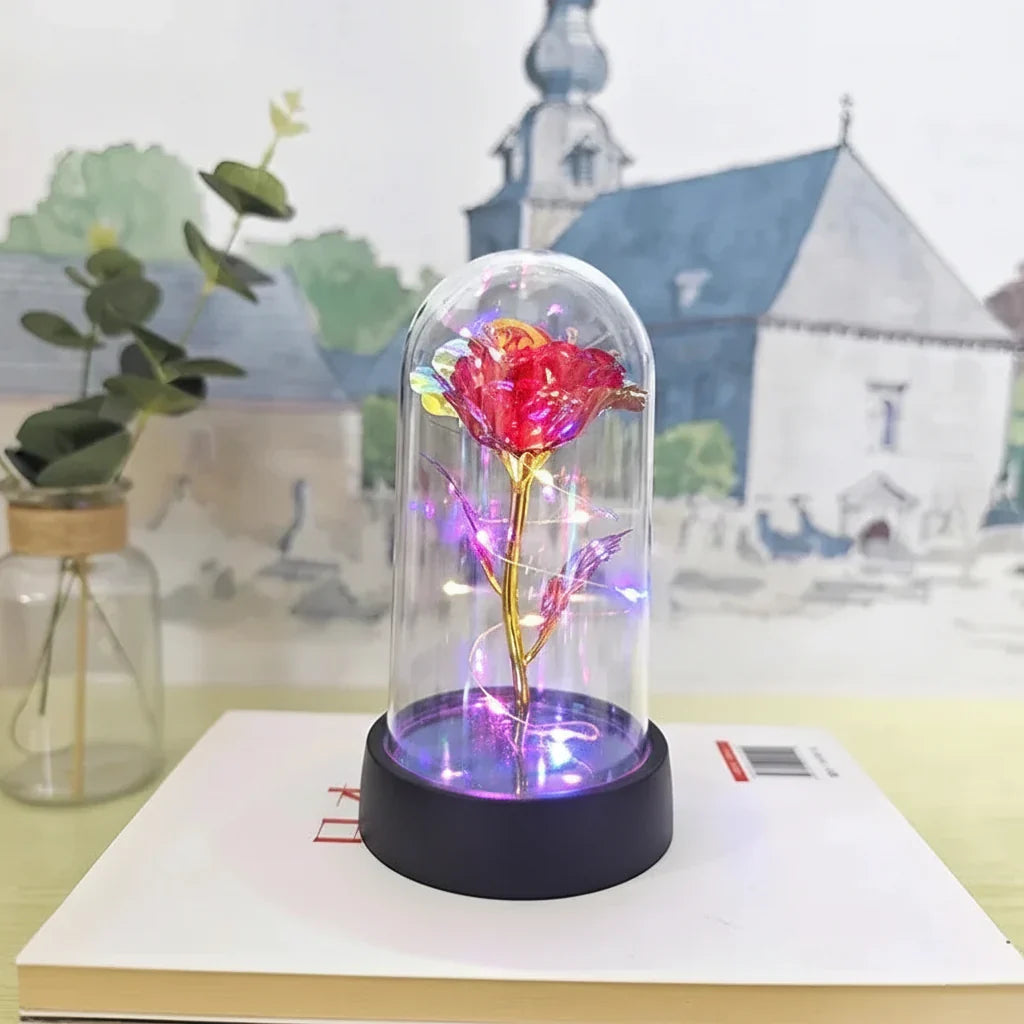 Lámpara LED rosa bajo cúpula de cristal, ideal para decoración romántica de mesa o regalo.