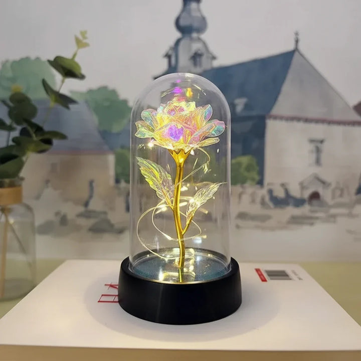 Luz nocturna LED rosa en cúpula de cristal, ideal para mesa de noche, creando un ambiente sereno y romántico.