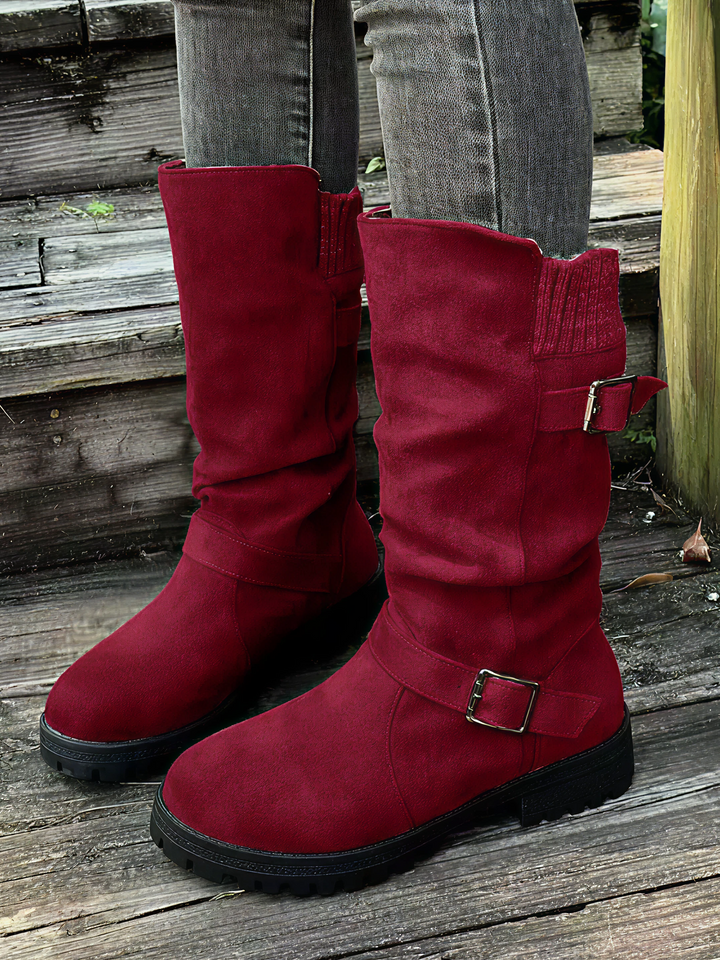 Botas de media caña para mujer con hebillas metálicas en correas, puño de punto acanalado y estilo moderno invernal.