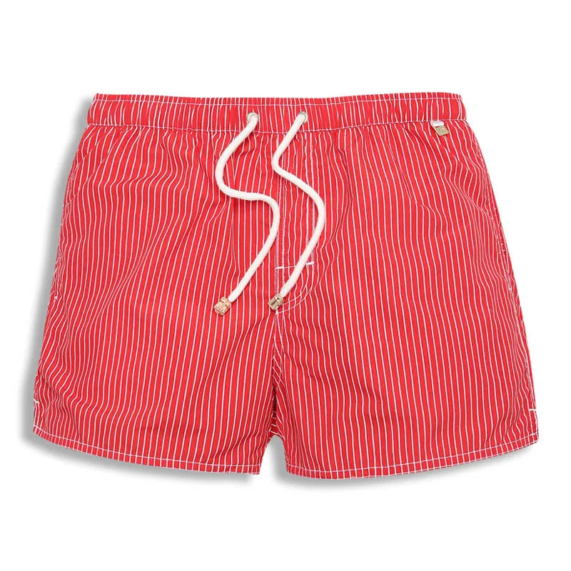 Moda masculina de playa: bañador a rayas, corto y moderno, para un look fresco en la piscina.