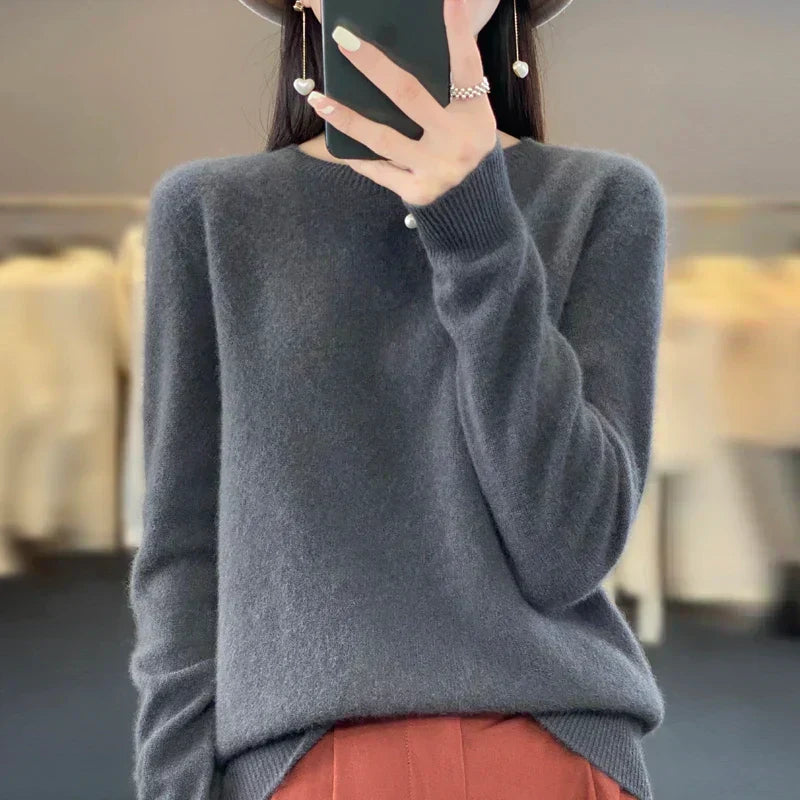 Mujer vistiendo suéter delgado gris, cuello redondo. Un jersey de manga larga, estilo casual de invierno.
