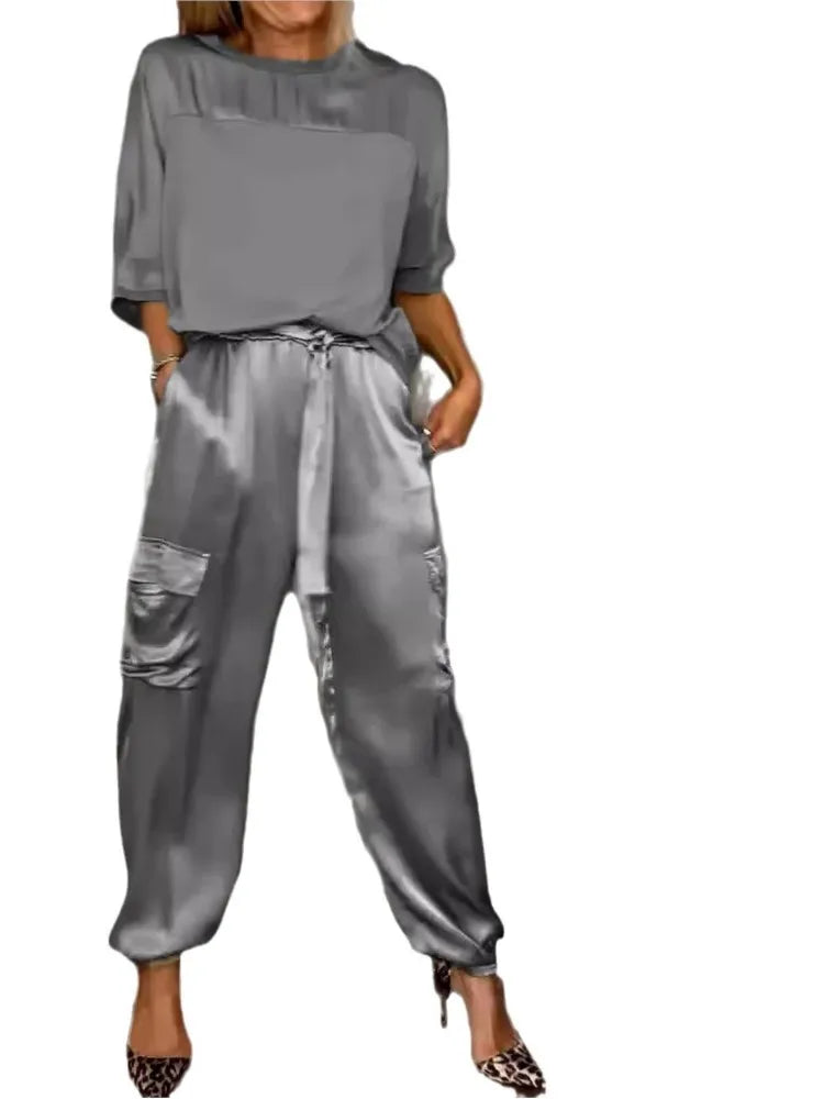 Modelo posando con conjunto satinado para mujer: top elegante y pantalón cargo, moda femenina versátil.