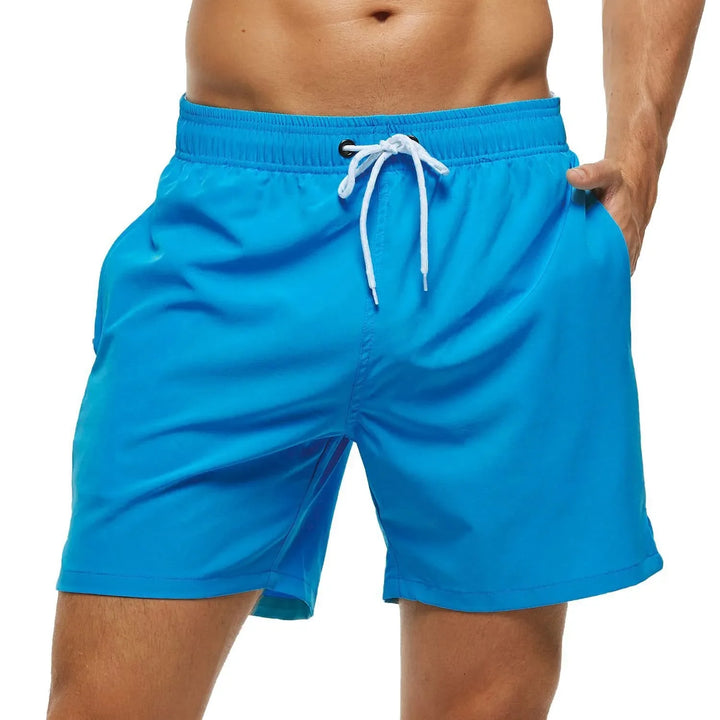 Bañador liso de hombre, ligero y versátil para vacaciones. Incluye práctico bolsillo con cremallera.