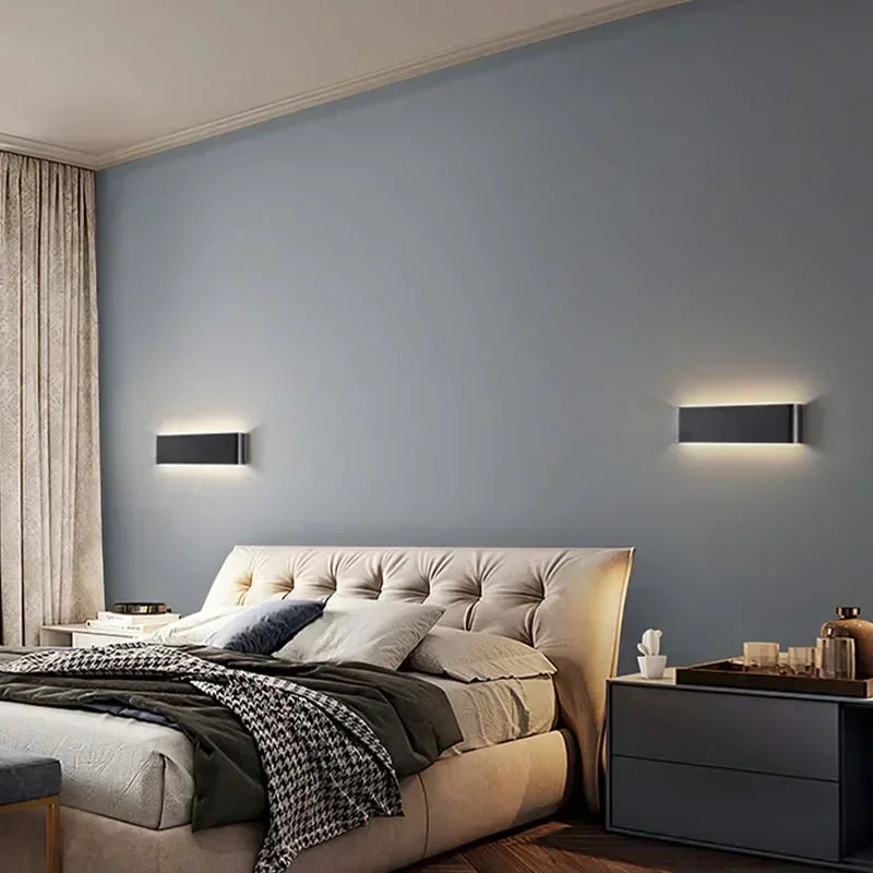 Aplique LED negro minimalista, creando ambiente moderno en sala de estar.