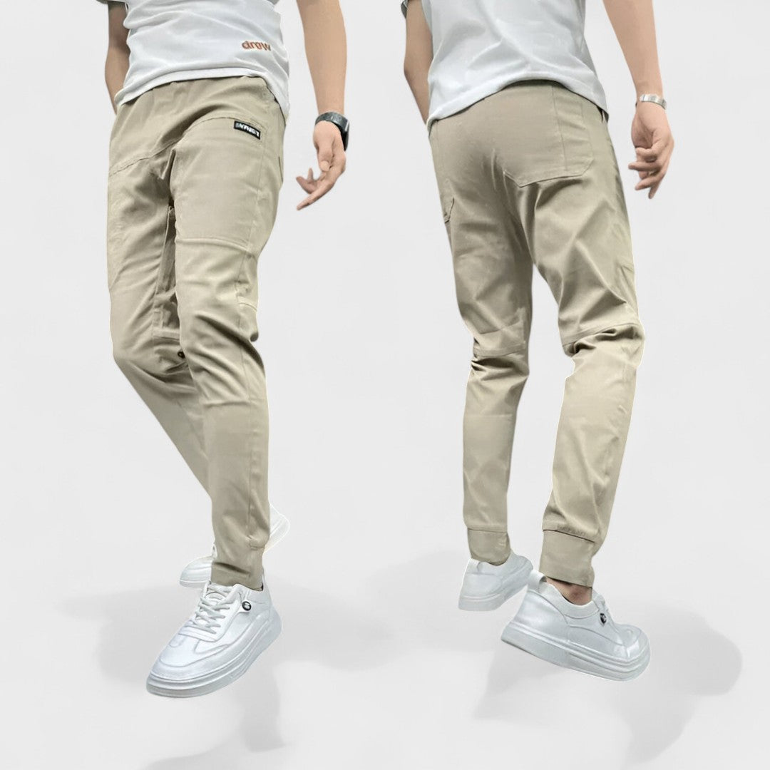 Hombre vistiendo pantalones cargo flexibles con múltiples bolsillos, color caqui, perfectos para comodidad y moda urbana.