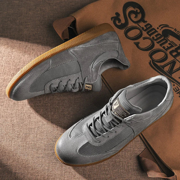 Hombre con zapatillas de ante y malla. Calzado urbano deportivo versátil, ideal para comodidad y estilo diario.
