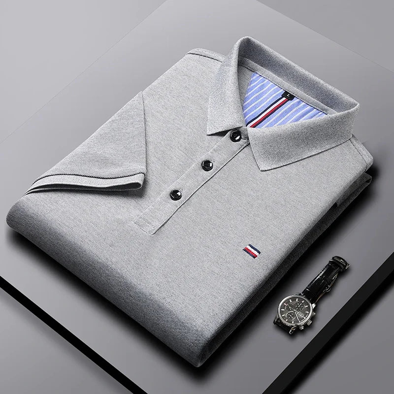 Hombre vistiendo polo azul clásico, manga corta, corte regular, estilo casual de algodón. Comodidad y moda.