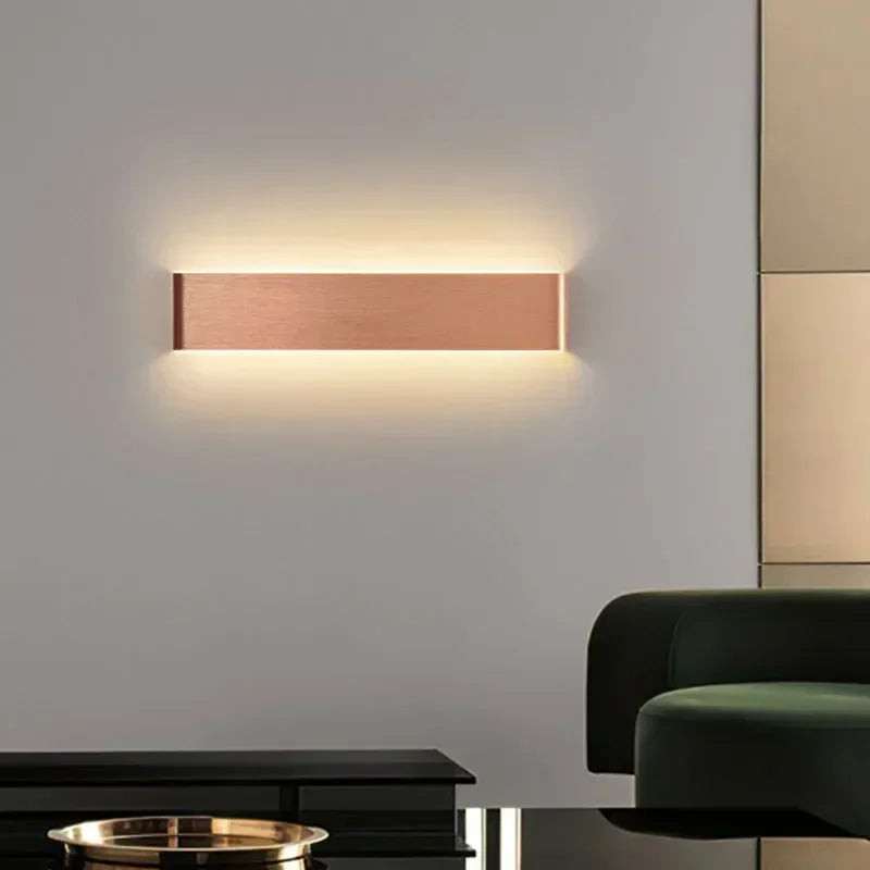 Aplique LED moderno minimalista en pared blanca, luz cálida para salón.
