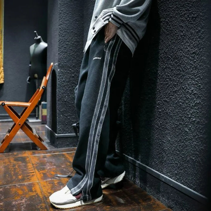 Pantalones anchos de hombre con cintura ajustable y cremallera, rayas laterales. Estilo urbano y deportivo.