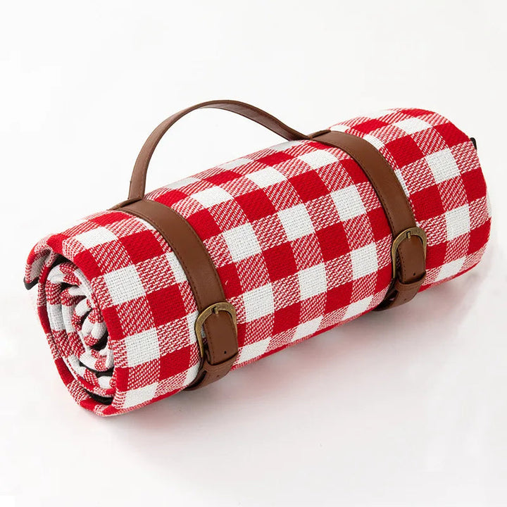 Accesorio de picnic: manta impermeable y portátil con correa de cuero, esencial para el exterior.