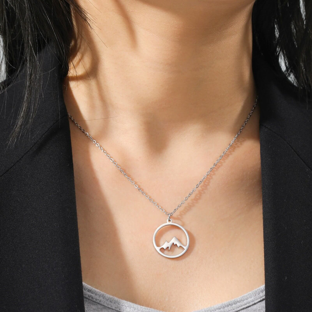 Collar de acero inoxidable con dije de montaña, ideal para amantes de la aventura.