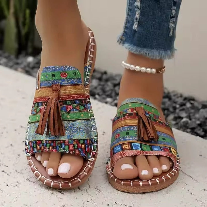 Sandalias planas de mujer con flecos estilo boho en color rojo, cómodas y artesanales para la playa.
