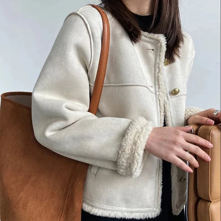 Mujer en ciudad luciendo abrigo lujoso de invierno. Ropa de abrigo elegante y moderna para otoño-invierno.
