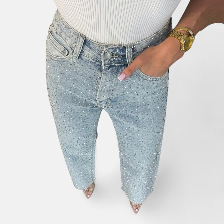 Detalle de la textura denim y los apliques de pedrería en estos modernos vaqueros de mujer de pierna ancha.
