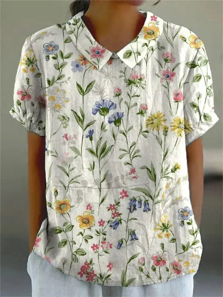 Primer plano del delicado bordado floral en blusa de manga corta para mujer. Diseño chic y casual de verano.
