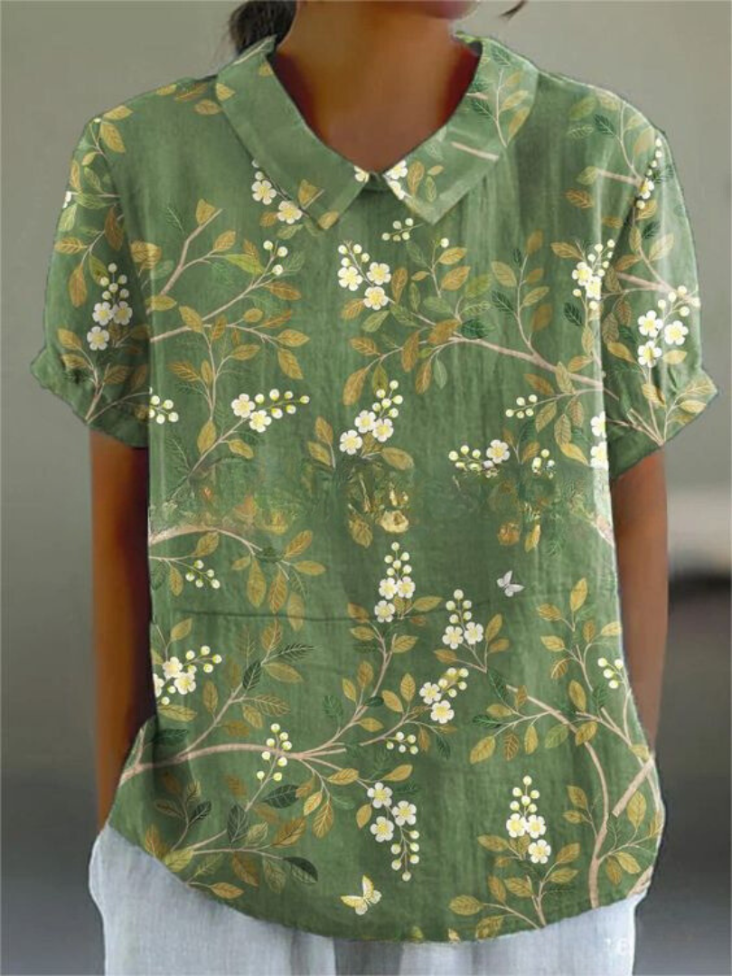 Mujer vistiendo blusa bordada de manga corta, cuello camisero. Estilo casual chic para primavera y verano.