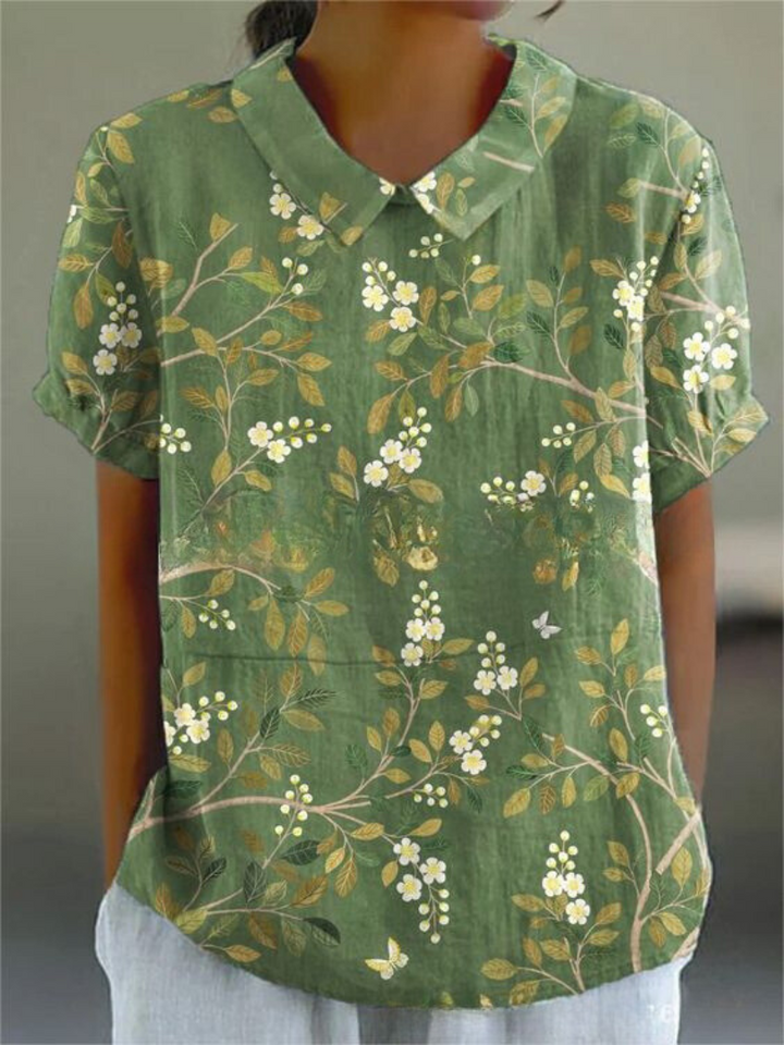 Mujer vistiendo blusa bordada de manga corta, cuello camisero. Estilo casual chic para primavera y verano.
