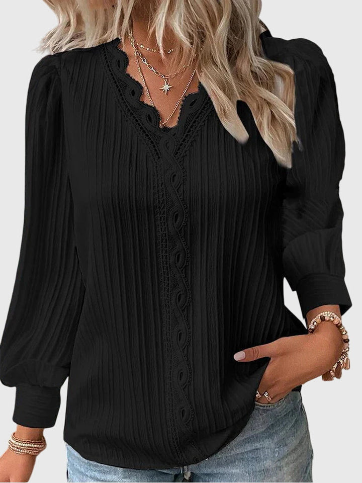 Blusa femenina de manga larga con prominente cuello V y finos detalles de encaje. Estilo elegante y moderno para mujer.