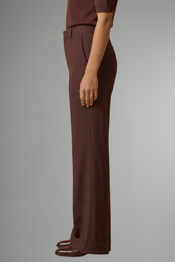 Mujer posando con conjunto de pantalón ancho y top corto, moda casual femenina de temporada.