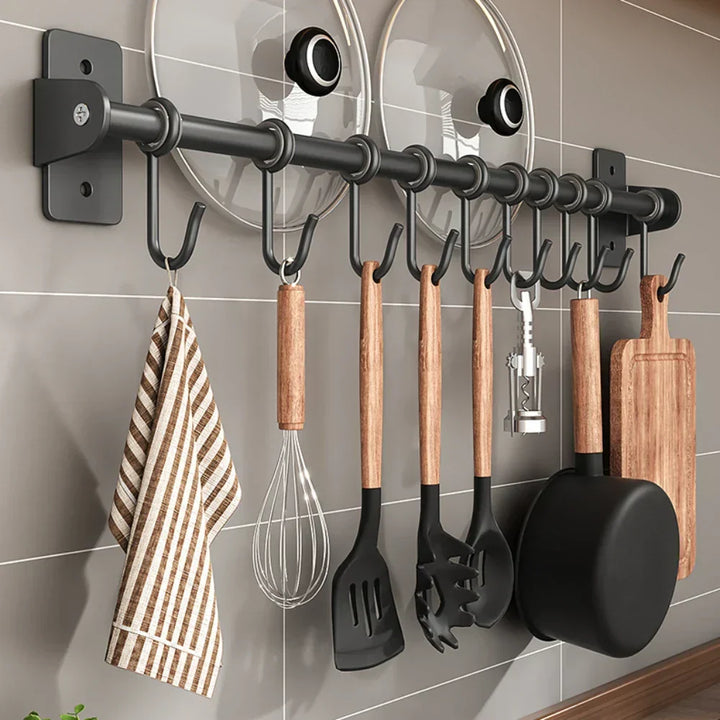 Organizador de cocina de acero negro para pared, con ganchos, ideal para utensilios y ahorro de espacio moderno.