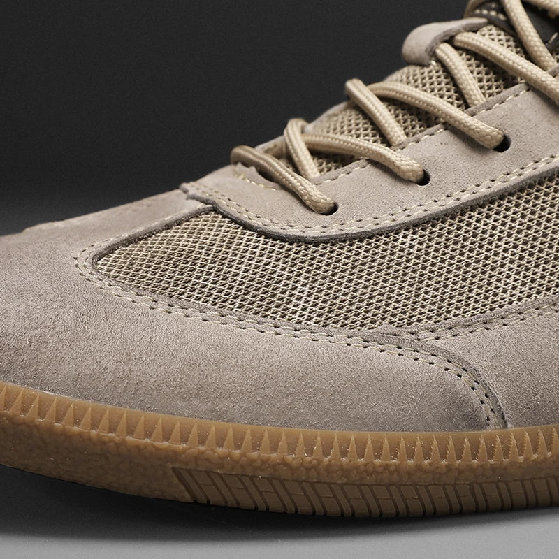 Vista lateral de zapatillas deportivas hombre. Diseño moderno de ante y malla, ideales para uso urbano y confort.