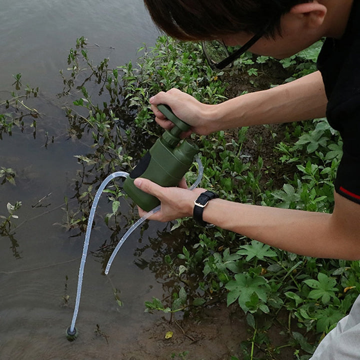 Familia en camping usando filtro de agua portátil, asegurando hidratación y agua potable para todos en la naturaleza.