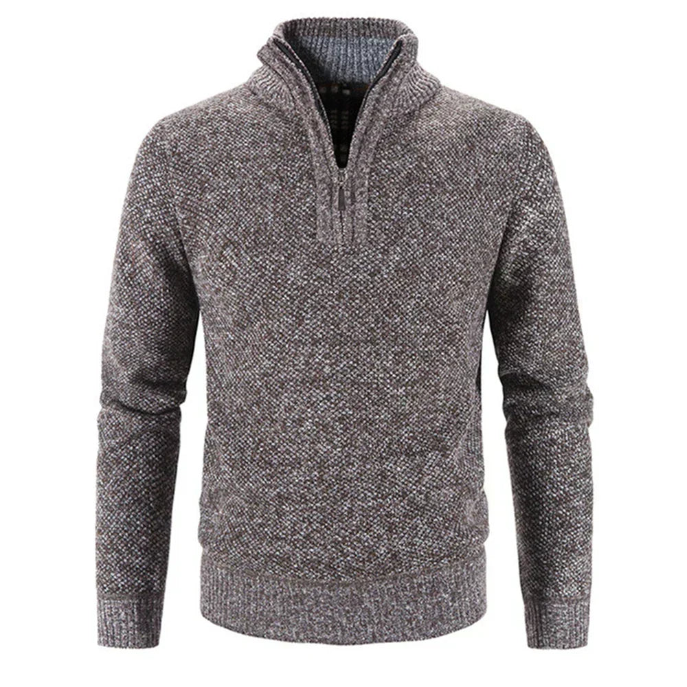 Hombre vistiendo jersey gris de media cremallera. Look casual moderno, ideal para otoño e invierno.