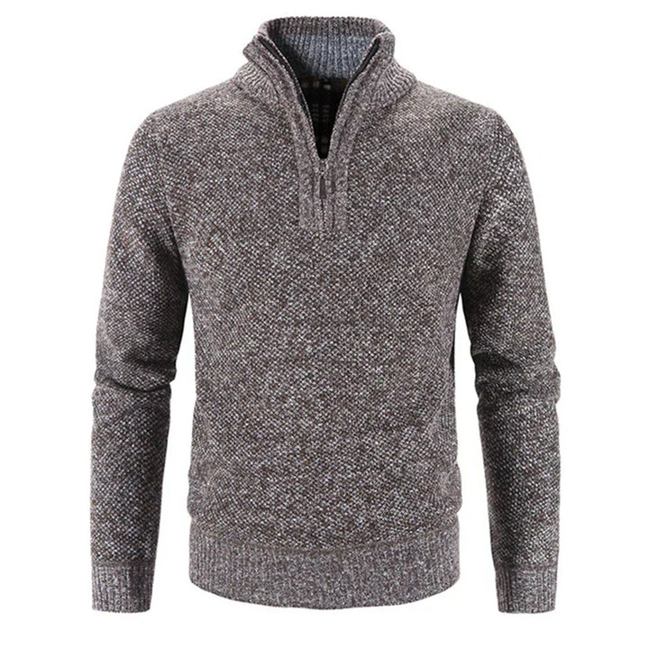 Hombre vistiendo jersey gris de media cremallera. Look casual moderno, ideal para otoño e invierno.
