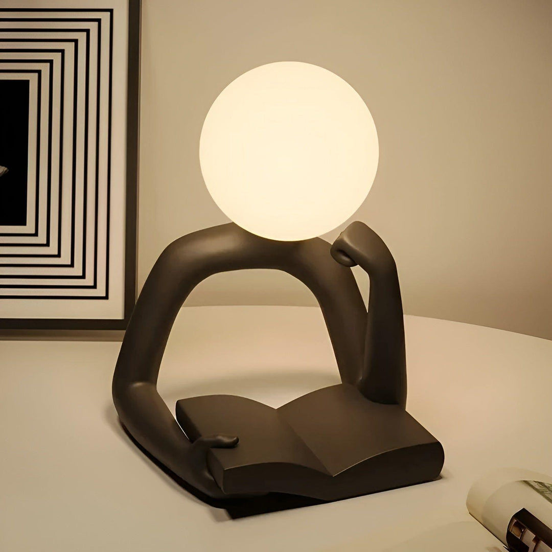 Pequeña lámpara de escritorio LED con diseño abstracto y moderno, ideal para iluminación de lectura y oficina.