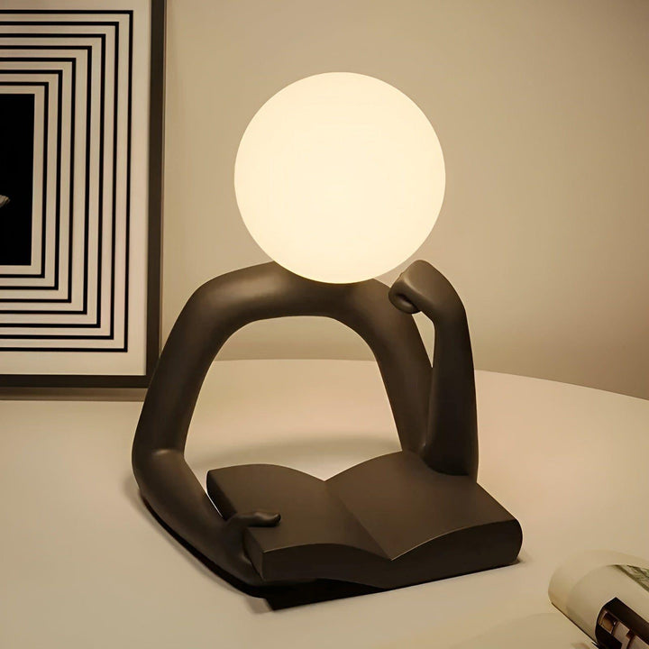 Pequeña lámpara de escritorio LED con diseño abstracto y moderno, ideal para iluminación de lectura y oficina.