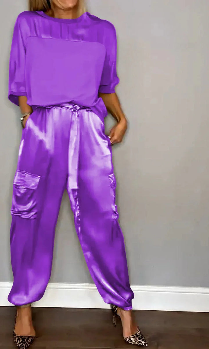 Detalle de la tela satinada del conjunto de mujer, mostrando el brillo del top suelto y el pantalón cargo.