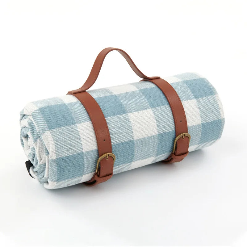 Manta de picnic de cuadros en la hierba, diseño familiar y superficie impermeable para confort.