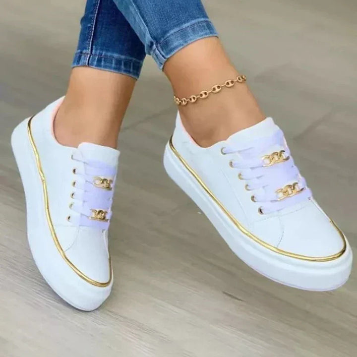 Zapatillas bajas de mujer blancas con detalles dorados, ideales para moda casual y estilo diario.