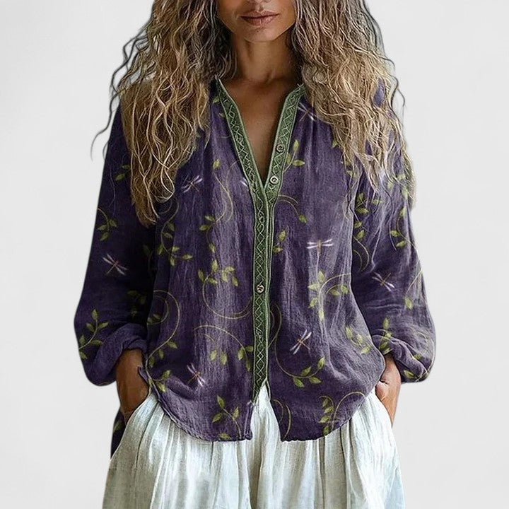 Blusa floral de mujer con manga larga y cuello V, ideal para primavera. Diseño elegante en tonos violeta y rosa.
