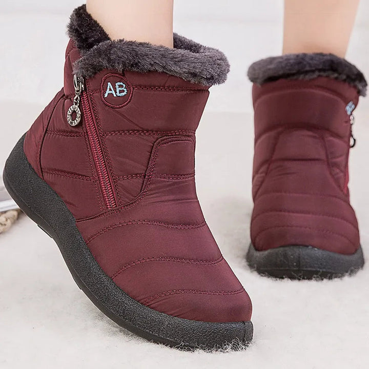 Mujer usando botas de invierno antideslizantes para caminar en la nieve, brindando seguridad y estilo.