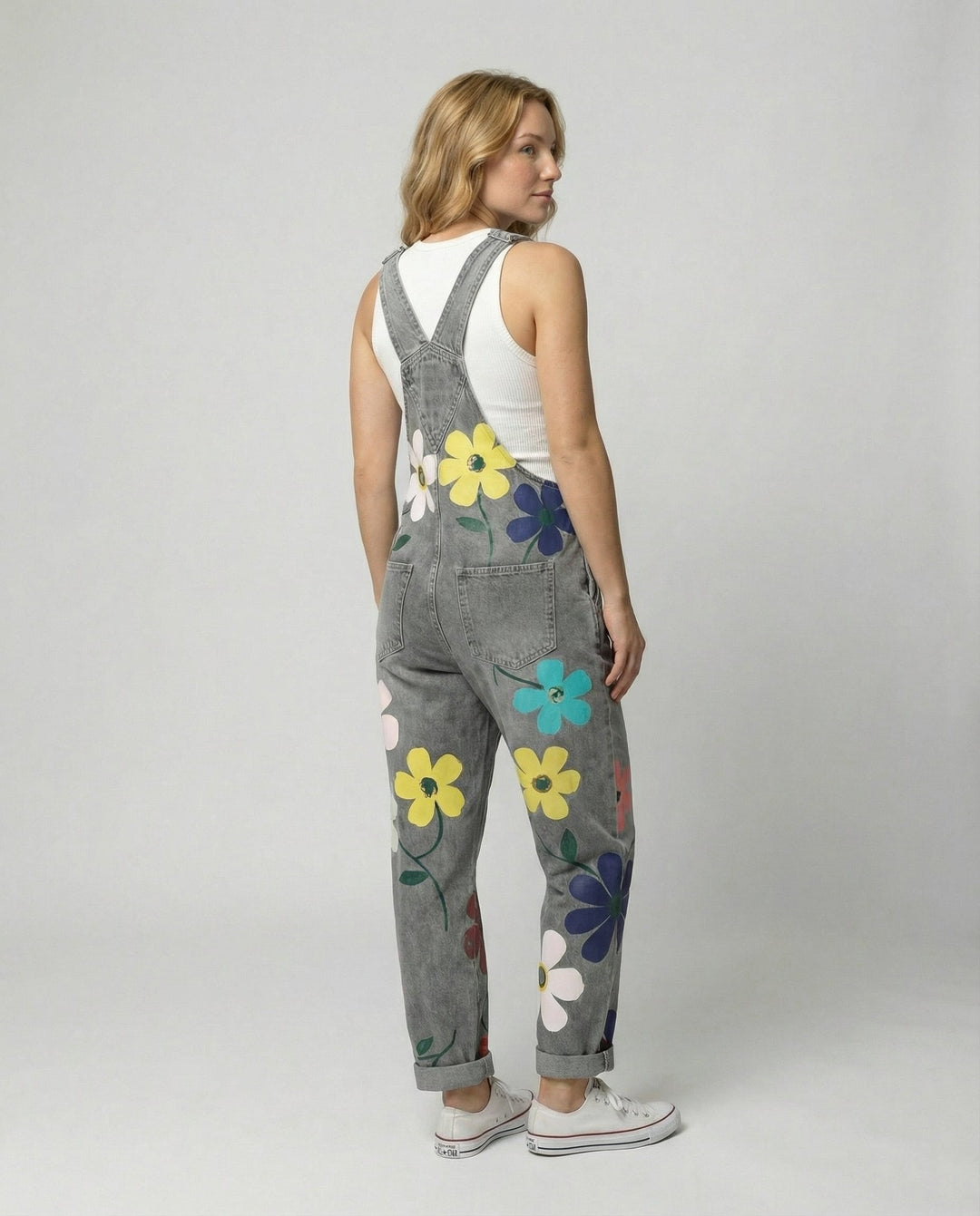 Vista frontal de peto vaquero estampado floral para mujer, con tirantes ajustables y estilo versátil.