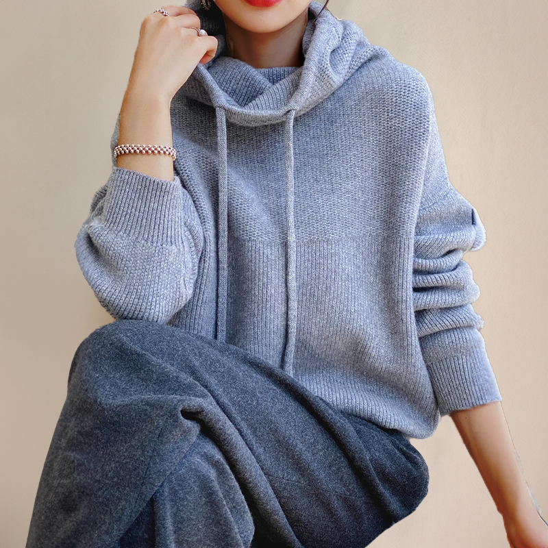 Detalle del cordón en sudadera de mujer con cuello vuelto y tejido texturizado, moda casual.