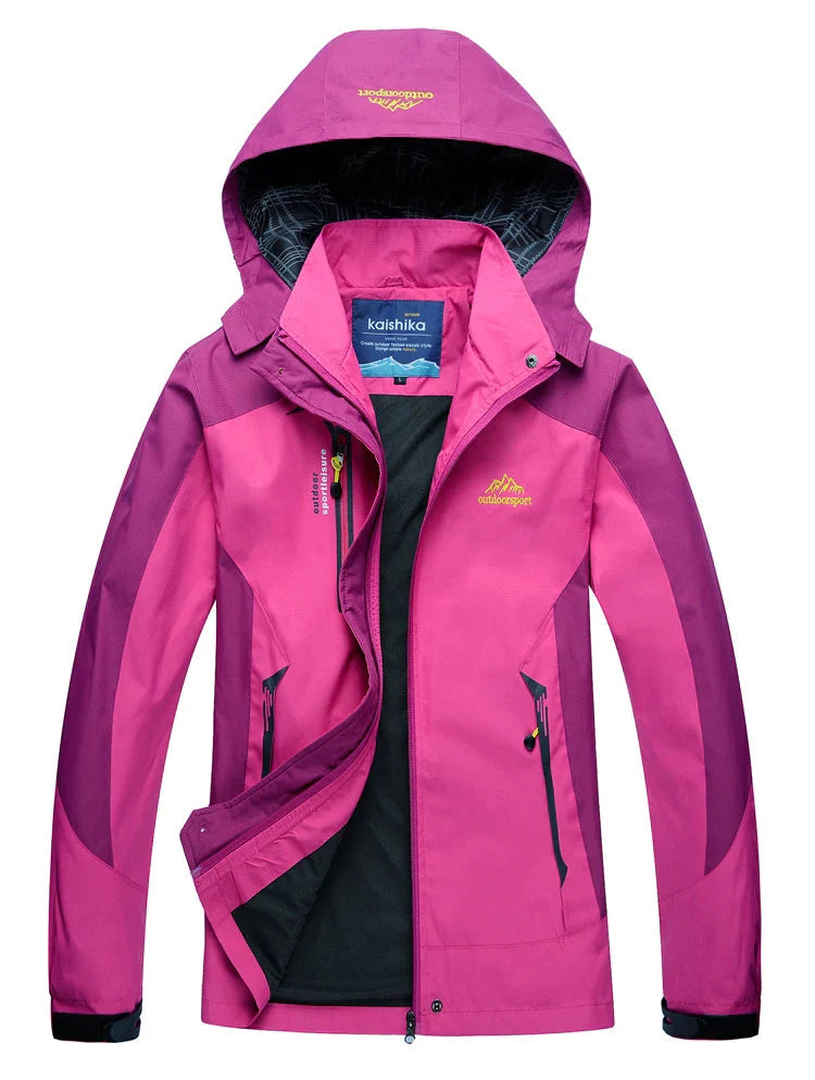 Mujer senderismo con chaqueta impermeable térmica en montaña. Abrigo cortavientos para protección frío exterior y lluvia.