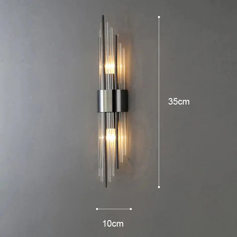 Aplique de pared contemporáneo de cristal con reflejos dorados. Aporta luz decorativa al hogar.