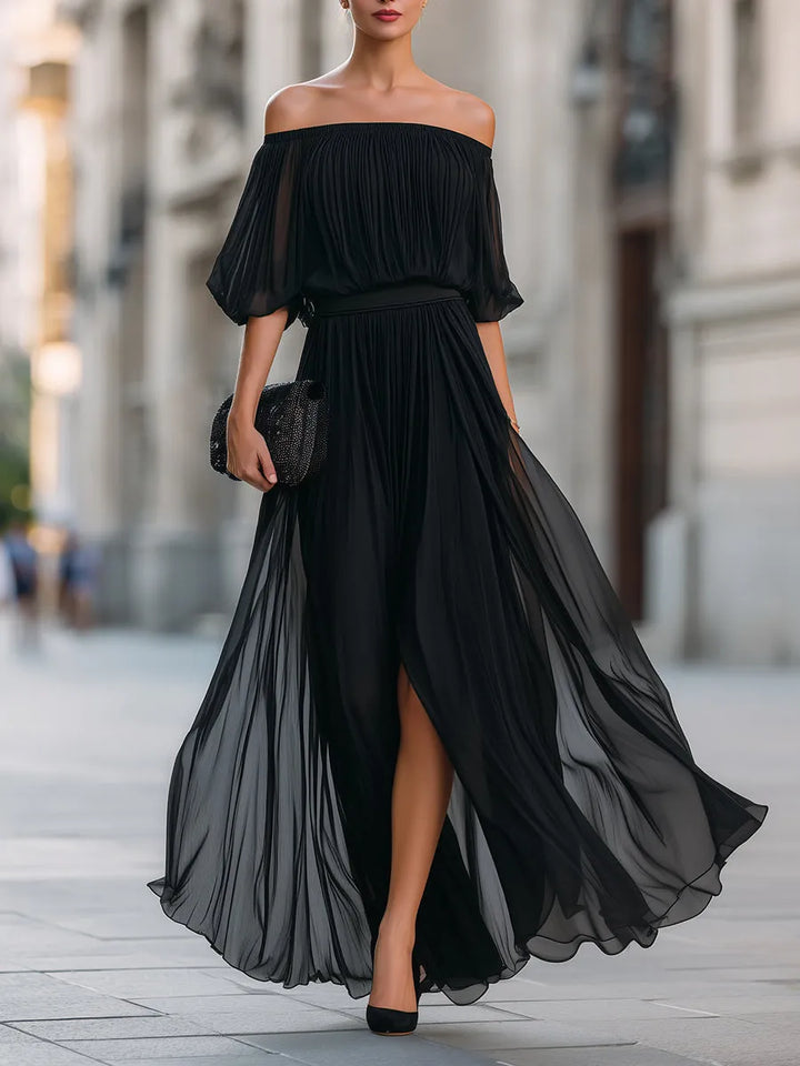 Detalle de vestido largo de fiesta para invitada. Escote asimétrico y falda plisada. Elegancia para mujer.